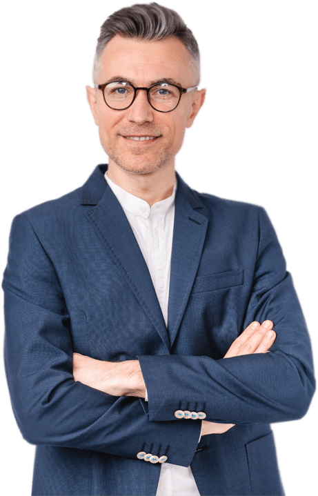 A professional man with glasses and gray hair smiles confidently while wearing a blue suit and white shirt, arms crossed. Suitable for business contexts.